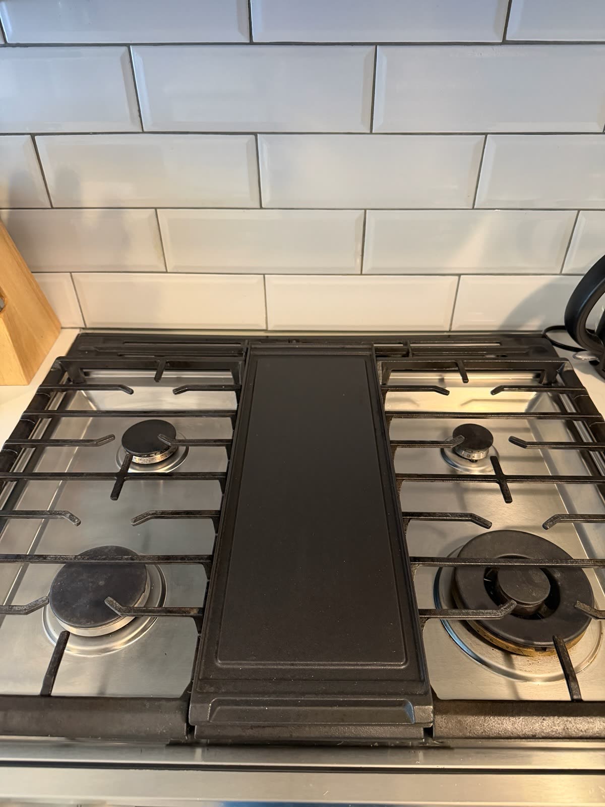 Cleared, wiped-down gas cooktop and griddle after cleaning