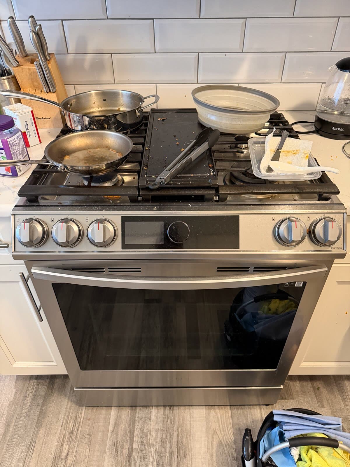 Gas range covered in pans and utensils before cleaning
